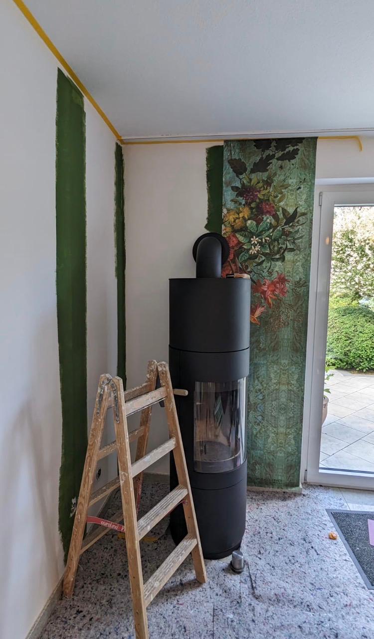 Florale Motivtapete an einer Wand neben einem Kamin während der Arbeiten
